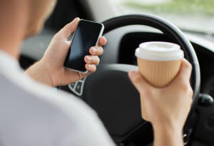 man using phone while driving the car